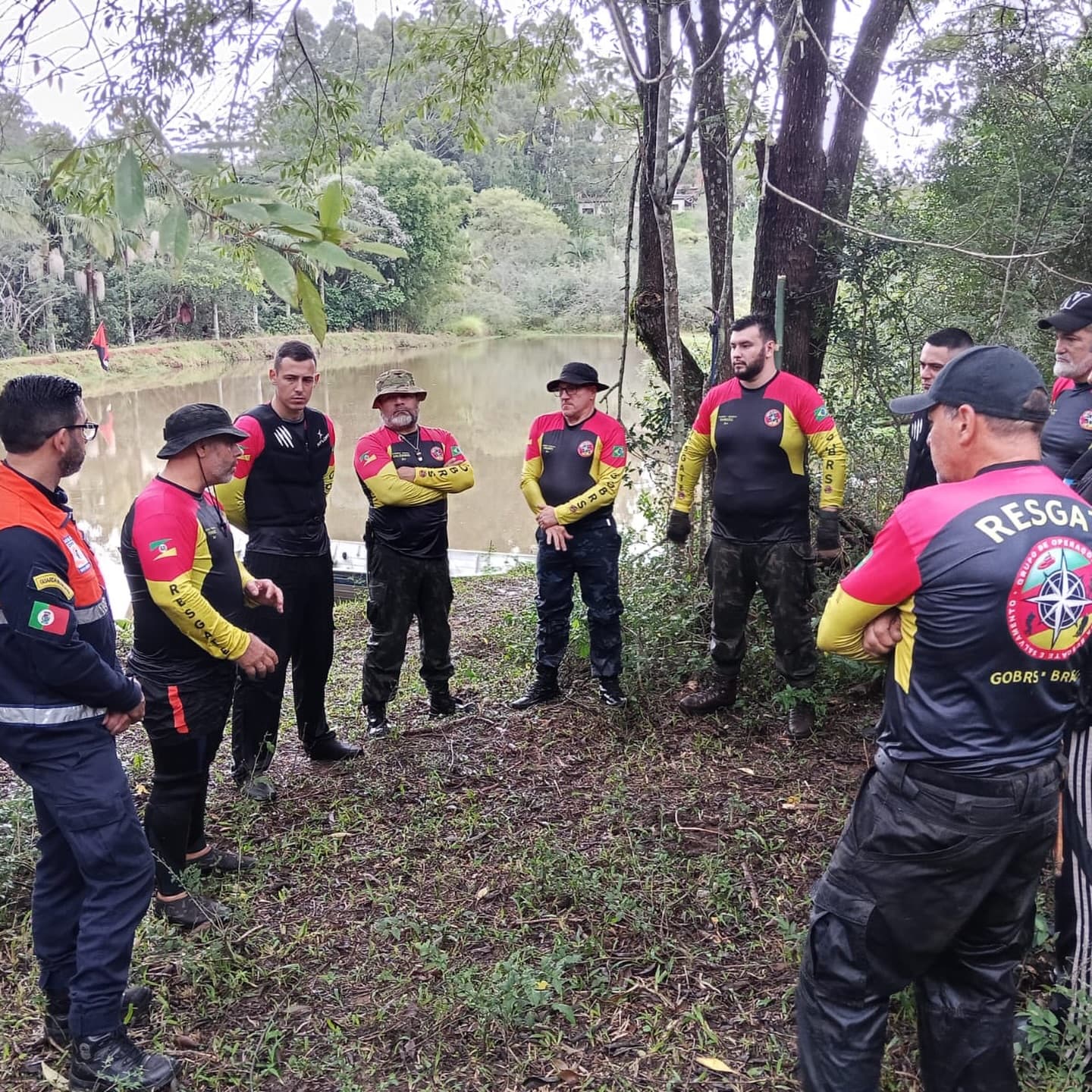 Voluntários do GOBRS reunidos em briefing operacional às margens de um açude